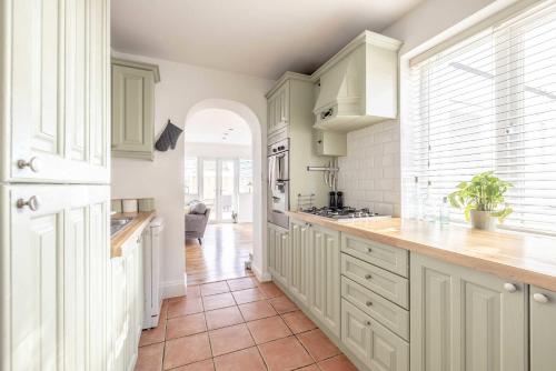 a kitchen with white cabinets and a tile floor at Host & Stay - Meadow Way in Windsor