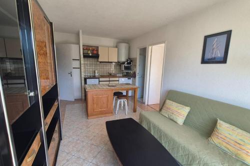 un salon avec un canapé et une cuisine dans l'établissement Apartment with pool - near beach, à Saint-Mandrier-sur-Mer