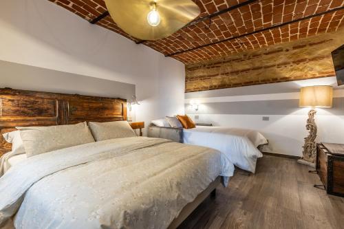 a bedroom with two beds and a wooden ceiling at Le Zucche Vuote in Quargnento
