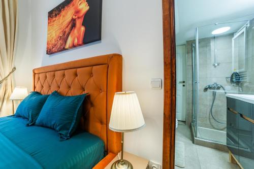 a bedroom with a blue bed and a shower at Old City Lux 2 in Braşov