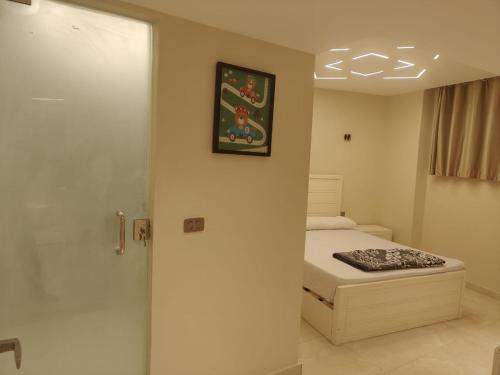 Un dormitorio con una cama y un cuadro en la pared. en Porto marina for rent, en El Alamein