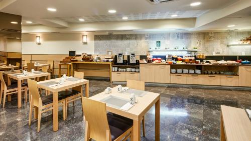 a restaurant with tables and chairs and a kitchen at Sercotel Codina in Donostia-San Sebastián