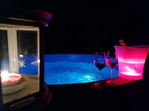 two wine glasses sitting next to a swimming pool at Camera Deluxe - Cuore Selvatico in Monno