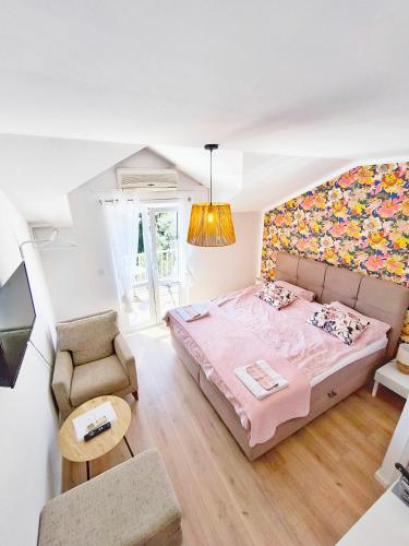 a bedroom with a pink bed and a couch at Villa Kipre in Cavtat