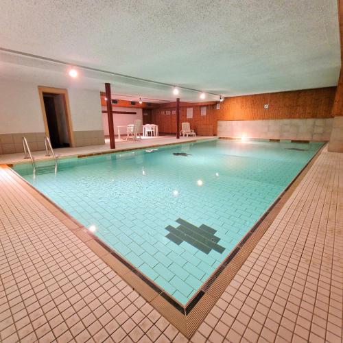 a large swimming pool in a hotel room at Appartement Veisivis 74 - Tout confort avec piscine in La Forclaz