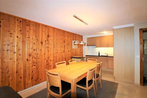 a kitchen with a wooden dining room table and chairs at Appartement Veisivis 74 - Tout confort avec piscine in La Forclaz