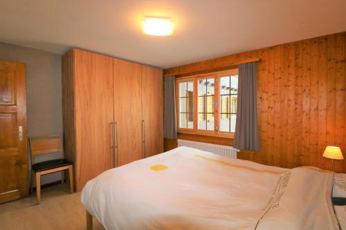 a bedroom with a white bed and a window at Appartement Veisivis 74 - Tout confort avec piscine in La Forclaz