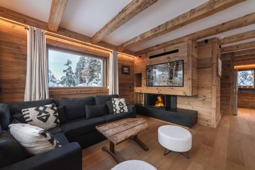 un salon avec un canapé et une cheminée dans l'établissement Pas de l’Ourson - Megève - Chalet with Sauna, à Megève
