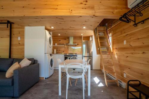 a living room with a table and a kitchen at Spa pool Private Lake - Chalet Hello in Saint-Alphonse-Rodriguez