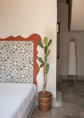 a potted plant in a basket next to a bed at La Sataqui in Cansaulim