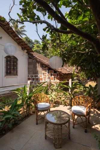 a patio with chairs and a table and a building at La Sataqui in Cansaulim