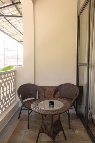 a table and two chairs on a balcony at La Sataqui in Cansaulim