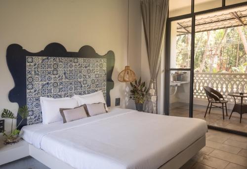 a bedroom with a large bed and a balcony at La Sataqui in Cansaulim