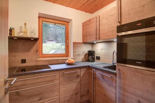 a kitchen with wooden cabinets and a window at Ferienwohnungen Kimpfbeck, Kreuth-Schärfen in Kreuth