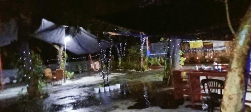 an outdoor patio at night with a table and lights at PINOY YOGA POLE PIYOPO LA UNION fan kubo 4 pax in Rimus