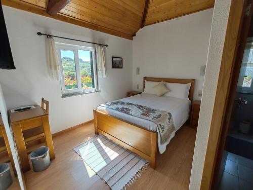 a bedroom with a bed and a window at Quintinha dos Emigrantes in Cujó