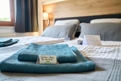 a bed with a blue blanket on top of it at Wirtseppelerhof Apartments in Leutasch