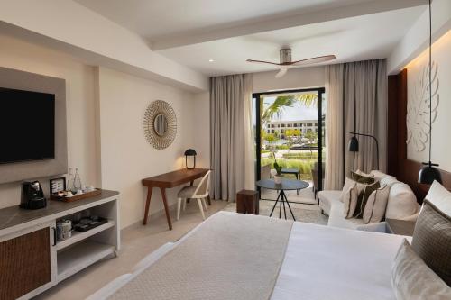 a hotel room with a bed and a television at Secrets Playa Esmeralda Resort & Spa - All Inclusive in Miches