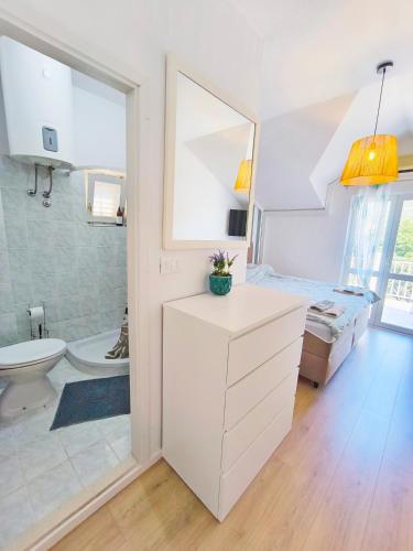 a white bathroom with a toilet and a sink at Villa Kipre in Cavtat