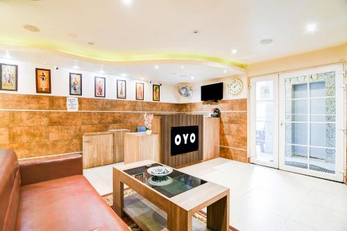 a living room with a couch and a table at Hotel O The Nest By Mint in Siliguri