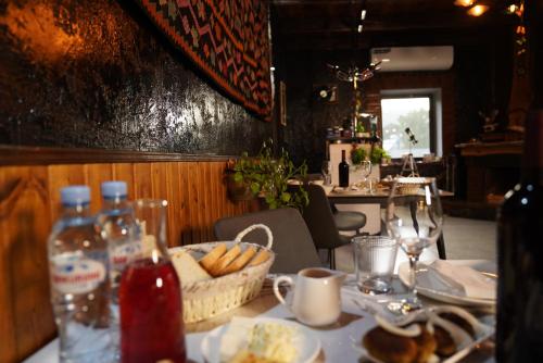 a table with a basket of bread and drinks on it at Hotel Hobbiton near Vardzia Caves in T'mogvi