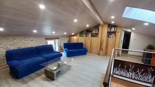 a living room with a blue couch and a table at Gîte familial Marais Poitevin Les glycines in Saint-Sigismond