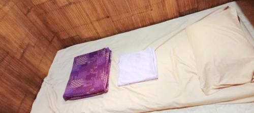 a purple tie and napkin on a bed at PINOY YOGA POLE PIYOPO LA UNION fan kubo 4 pax in Rimus
