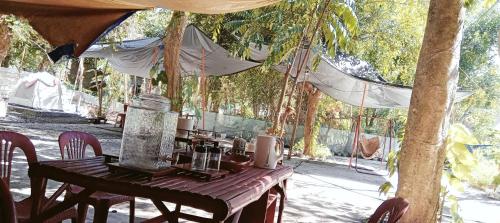 a wooden table with chairs under a tent at PINOY YOGA POLE PIYOPO LA UNION fan kubo 4 pax in Rimus