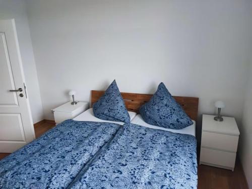 a bedroom with a blue and white bed with pillows at Ferienwohnung auf dem Lande in Niesgrau