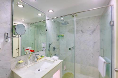 a bathroom with a shower and a sink and a mirror at Hotel Clarks Shiraz in Agra