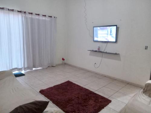 a living room with a flat screen tv on a wall at Hospedagem Alvinópolis in Atibaia