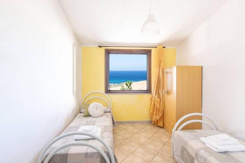 a room with two beds and a window with the ocean at Costa Verde - Panoramic Stay Terrace Wifi BBQ AC in Torre Dei Corsari