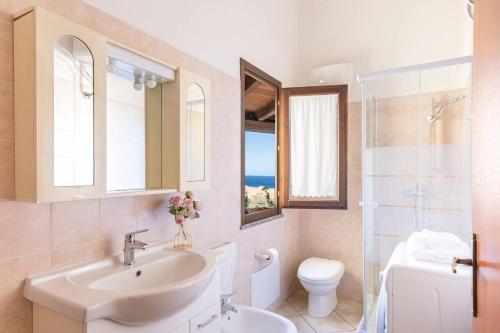 a bathroom with a sink and a toilet and a window at Costa Verde - Panoramic Stay Terrace Wifi BBQ AC in Torre Dei Corsari