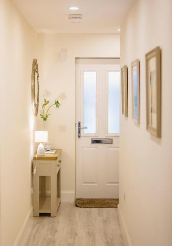a hallway with a white door and a table at 2 Bedroom Apartment in North Berwick in North Berwick