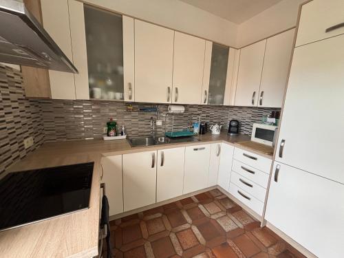 a kitchen with white cabinets and a sink at AppartementHalle in Halle