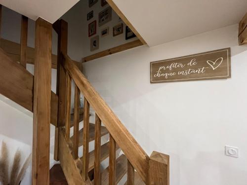a wooden staircase in a house with a sign on the wall at Gîte DouDou in Saint-Sever