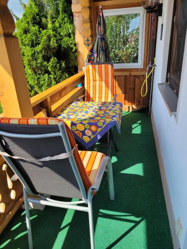 a porch with a chair and a table and a chair at Ferienwohnung bei Helga in Tittmoning