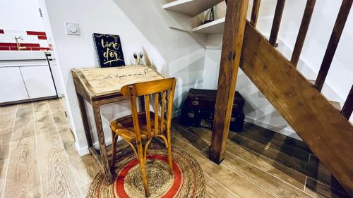 a staircase with a wooden chair next to a table at Gîte DouDou in Saint-Sever