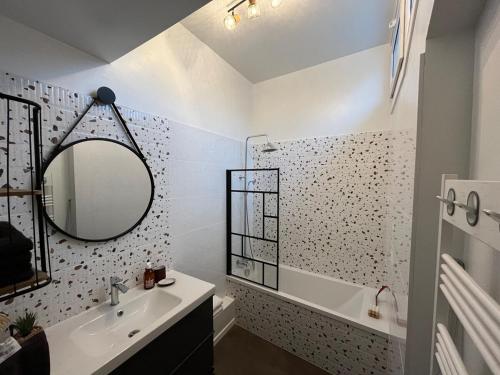 a bathroom with a sink and a mirror and a tub at Gîte DouDou in Saint-Sever