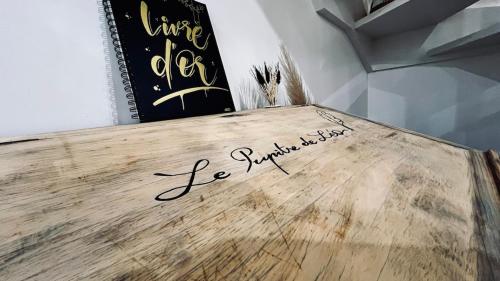 a writing on a wooden table with a book at Gîte DouDou in Saint-Sever