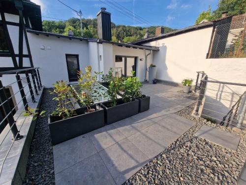 a courtyard of a house with potted plants at FEWO am Rathaus in Heimbach