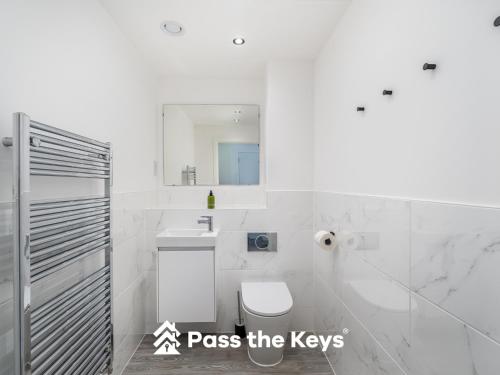 a white bathroom with a toilet and a sink at Pass the Keys Modern Townhouse with Garden and Parking in Ascot in Ascot