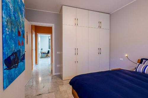 a bedroom with white cabinets and a blue bed at Yachting Residence in Ghiffa