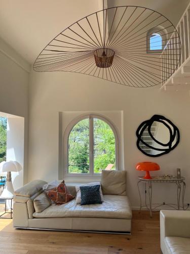 a living room with a couch and a large chandelier at Villa Denise in Bidart