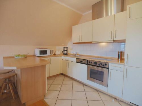 a kitchen with white cabinets and a counter top at Möwenblick Fewo Ramm in Warnemünde