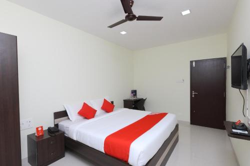 a bedroom with a bed and a flat screen tv at Super Hotel O Perfect Stay Near Meenambakkam Metro Station in Chennai