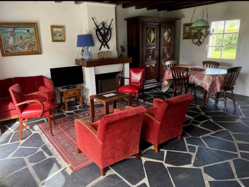 un salon avec des chaises rouges et une table dans l'établissement Maison confortable près de la mer et du bourg, calme et authenticité à Sauzon. - FR-1-418-153, à Sauzon