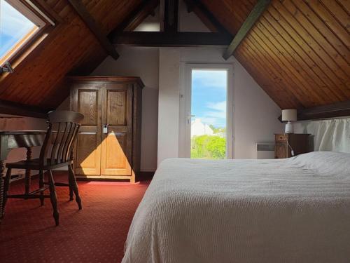 une chambre avec un lit, un bureau et une fenêtre dans l'établissement Maison confortable près de la mer et du bourg, calme et authenticité à Sauzon. - FR-1-418-153, à Sauzon