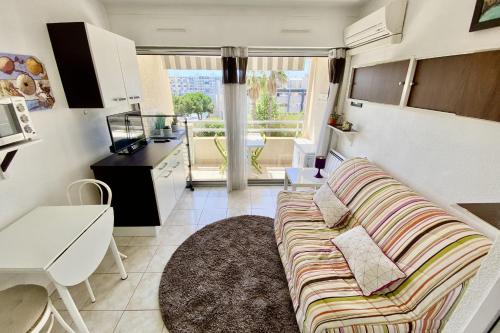 un salon avec un canapé et une cuisine dans l'établissement Charming studio near the harbour, à Mauguio