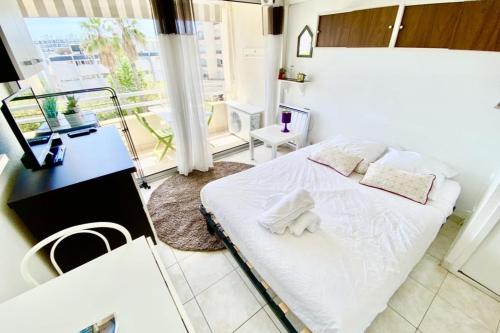 - une chambre avec un lit blanc et un balcon dans l'établissement Charming studio near the harbour, à Mauguio